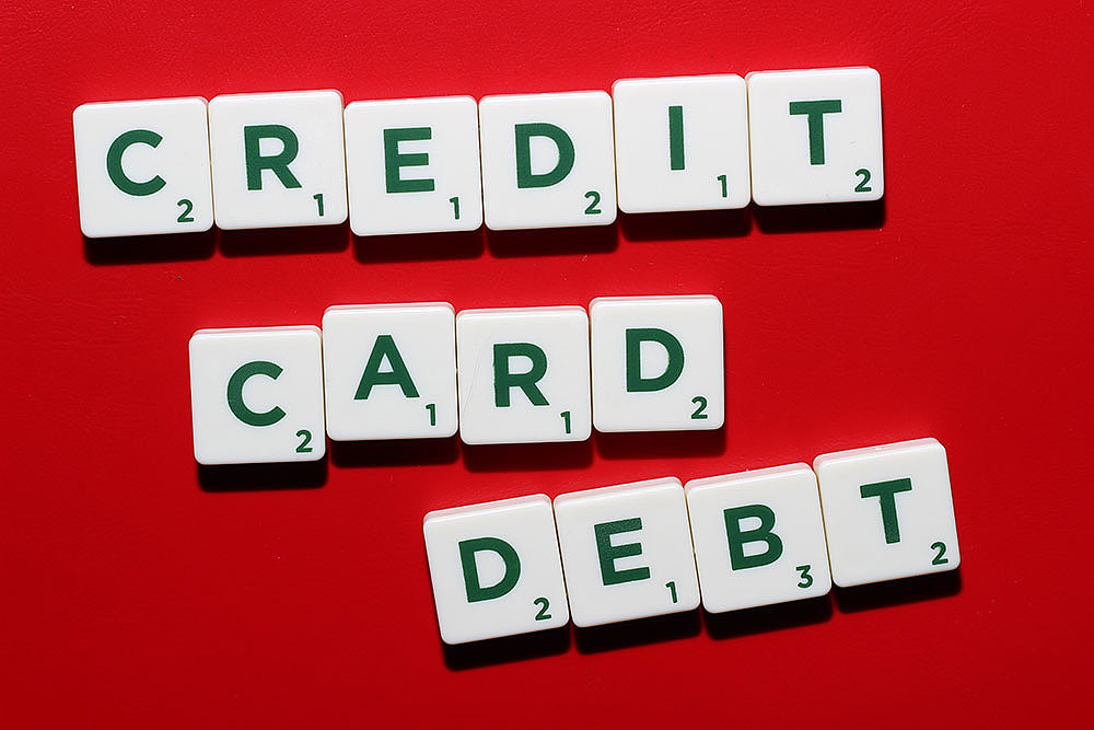 빨간 배경 위에 CREDIT CARD DEBT라는 글자를 만든 알파벳 타일